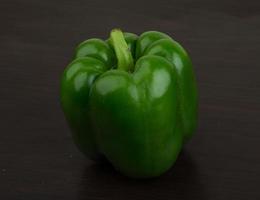 Green Bulgarian pepper on wooden background photo