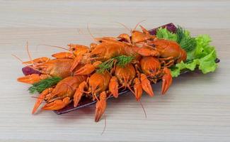 Boiled crayfish in a bowl on wooden background photo