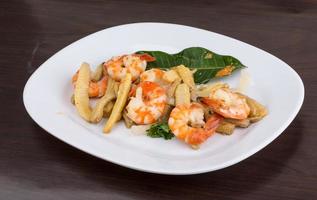 Shrimp and corn salad on the plate and wooden background photo