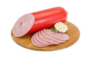 Sausages on wooden board and white background photo