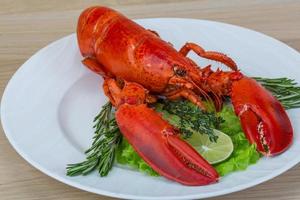 Boiled lobster on the plate and wooden background photo