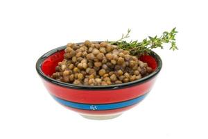 Backed lentils in a bowl on white background photo