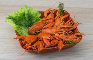 Boiled crayfish in a bowl on wooden background photo