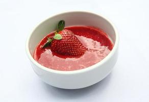 Strawberry puree in a bowl on white background photo