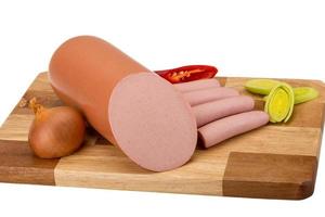 Sausages on wooden board and white background photo