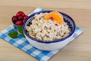 Oatmeal in a bowl on wooden background photo