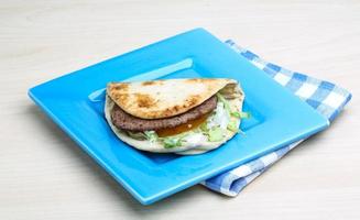 Greek pita on the plate and wooden background photo
