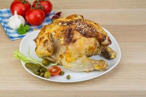 pollo a la parrilla en el plato y fondo de madera foto