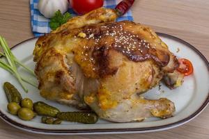 Grilled chicken on the plate and wooden background photo