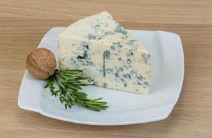 Blue cheese on the plate and wooden background photo
