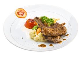 chuletas de cordero en el plato y fondo blanco foto