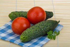 Tomato and cucumber on wooden background photo