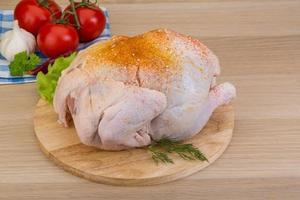 Raw chicken on wooden board and wooden background photo