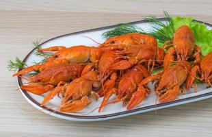 Boiled crayfish in a bowl on wooden background photo