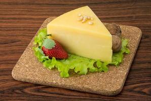 Parmesan cheese on wooden board and wooden background photo