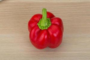 Red pepper on wooden background photo