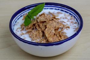 Cornfalkes breakfast in a bowl on wooden background photo