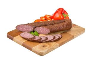 Sausages on wooden board and white background photo