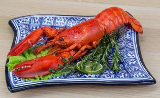 Boiled lobster on the plate and wooden background photo