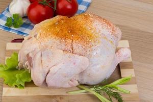 Raw chicken on wooden board and wooden background photo