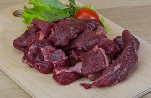 Raw venison on wooden board and wooden background photo