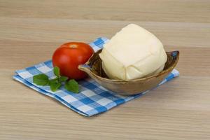 Mozzarella cheese in a bowl on wooden background photo