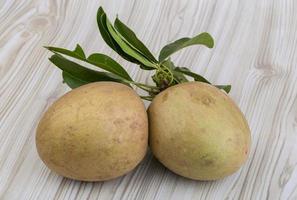 Sapodilla on wooden background photo