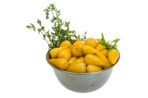 Yellow marinated pepper in a bowl on white background photo