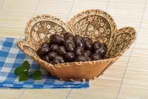 Almond in chocolate on wooden background photo