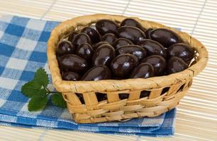 almendra en chocolate en una canasta sobre fondo de madera foto