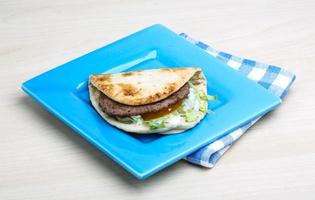 Greek pita on the plate and wooden background photo