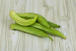 Okra vegetables on wooden background photo