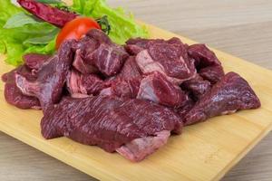 Raw venison on wooden board and wooden background photo