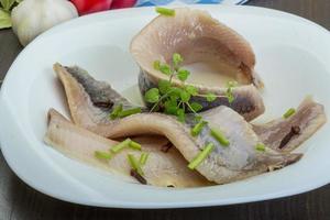 Herring fillet in a bowl on wooden background photo