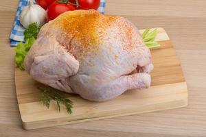 Raw chicken on wooden board and wooden background photo