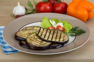 Grilled aubergine on the plate and wooden background photo