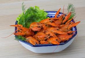 Boiled crayfish in a bowl on wooden background photo