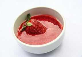 Strawberry puree in a bowl on white background photo