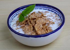 Cornfalkes desayuno en un bol sobre fondo de madera foto