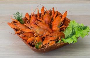 Boiled crayfish in a bowl on wooden background photo