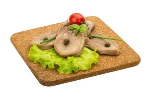 Beef tongue on wooden board and white background photo