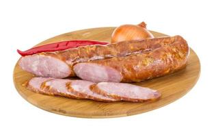 Sausages on wooden board and white background photo