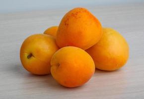 Apricots on wooden background photo