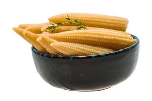 Baby corn in a bowl on white background photo