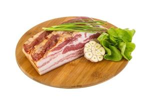 Bacon on wooden board and white background photo