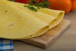 Tortilla on wooden board and wooden background photo