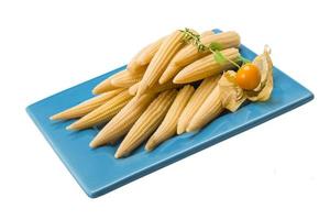 Baby corn on the plate and white background photo