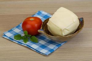 Mozzarella cheese in a bowl on wooden background photo