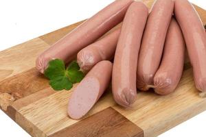 Sausages on wooden board and white background photo