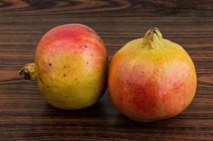 Yellow Pomegranet on wooden background photo